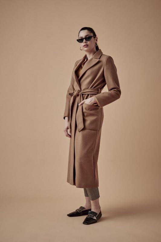Modella indossa cappotto lungo color cammello con cintura