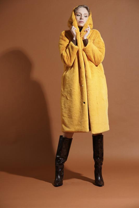 modella indossa cappotto in ecopelliccia giallo